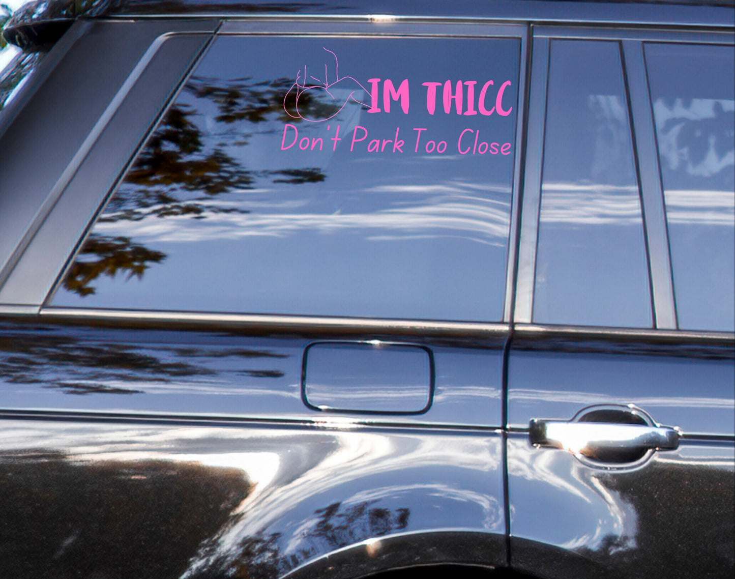Image of a black suv with a pink decal that says I'm Thicc, Don't Park To close