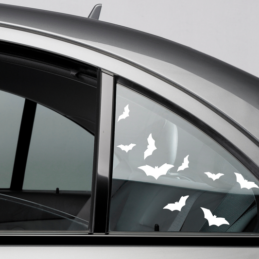 Matte White Flying Bats on a clear car rear window on a grey 4 door sedan