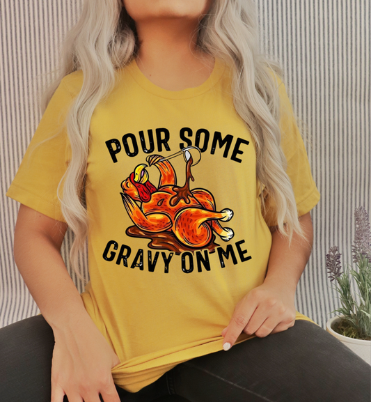Person wearing a yellow t-shirt with a graphic and text 'Pour some gravy on me'.