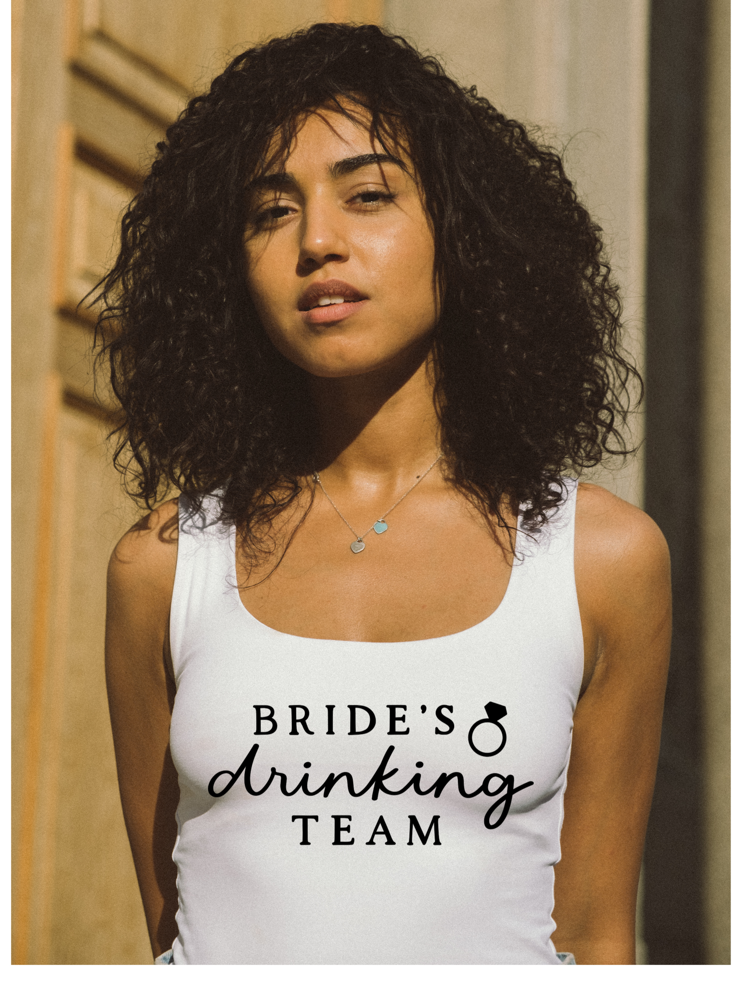 white tank top with the words "Bride's Drinking team" with a ring with a heart. 