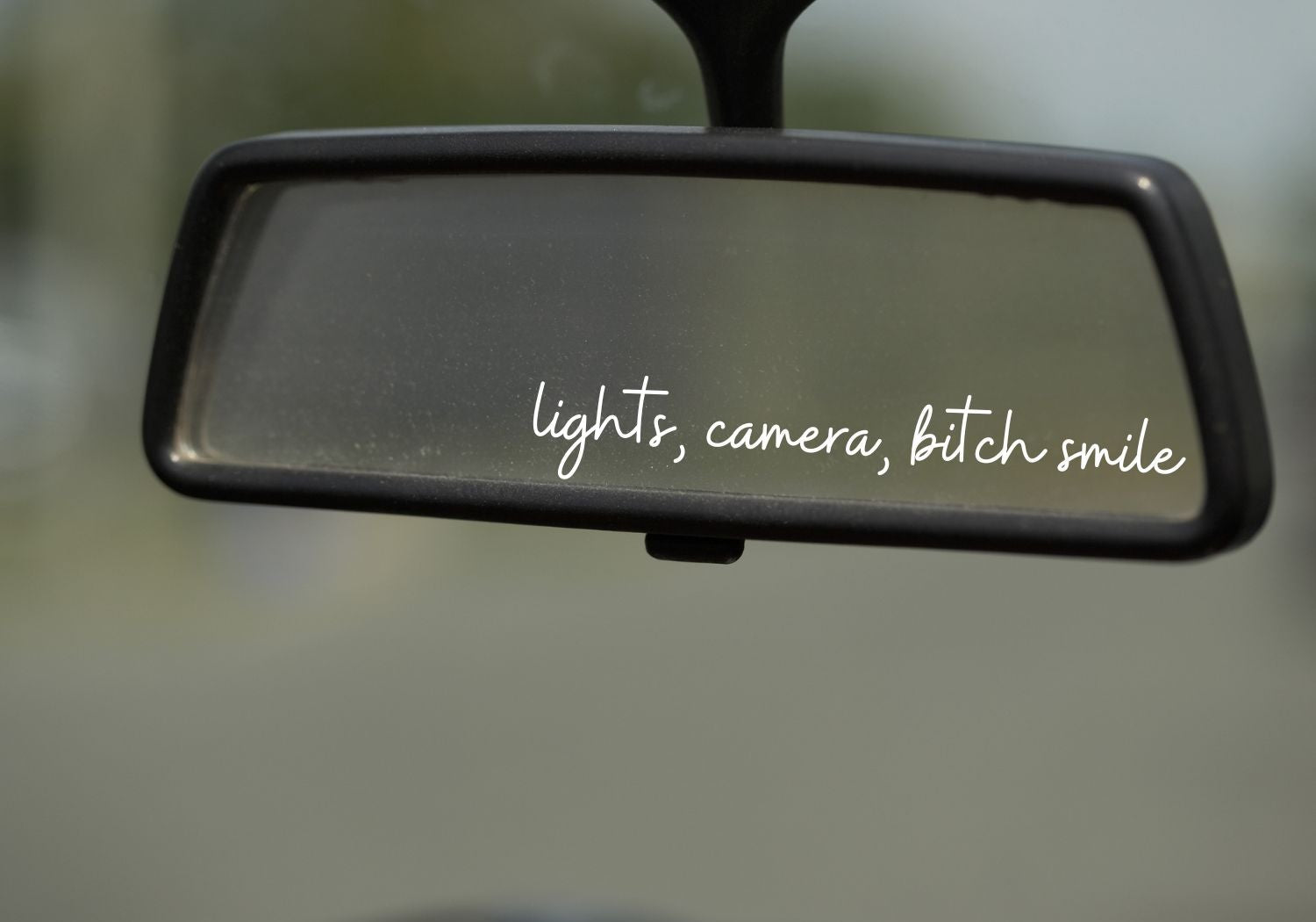 rear view mirror with a decal that says "Lights, Camera, Bitch Smile" 