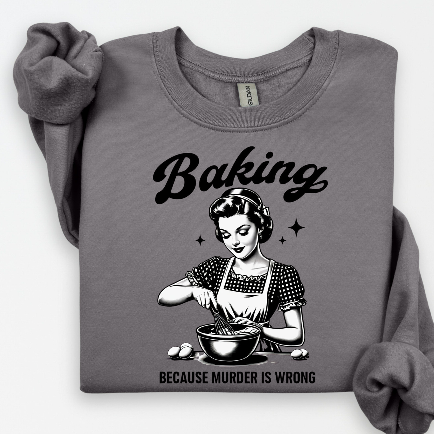 Gray sweatshirt with a graphic of a woman baking and text 'Baking because murder is wrong' on a white background.