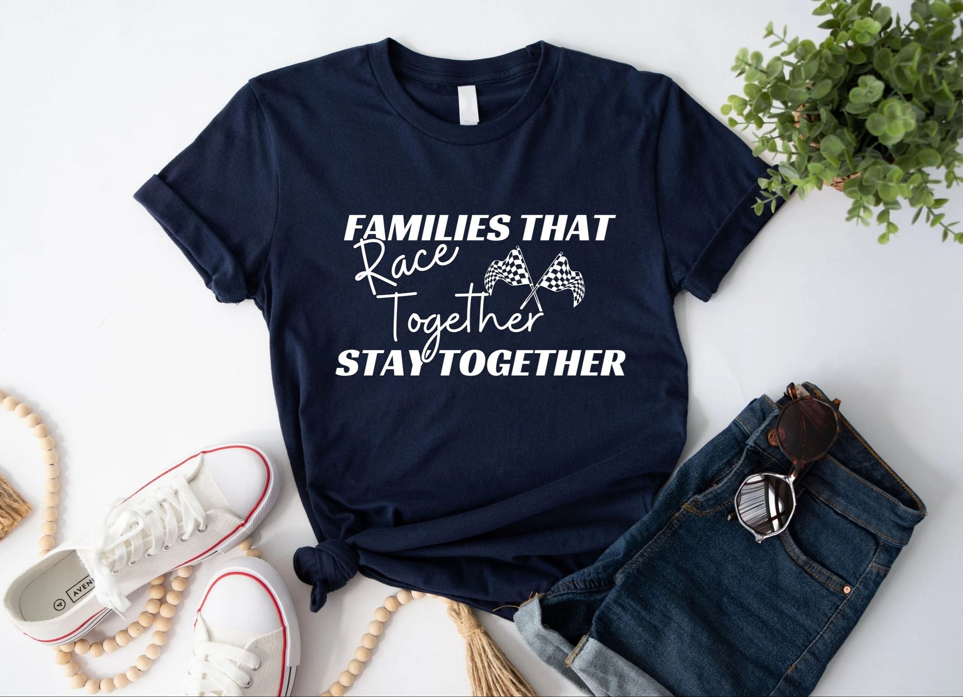 Tee with sneaker and shorts for show. The tee says Families that race together stay together with racing flags. 