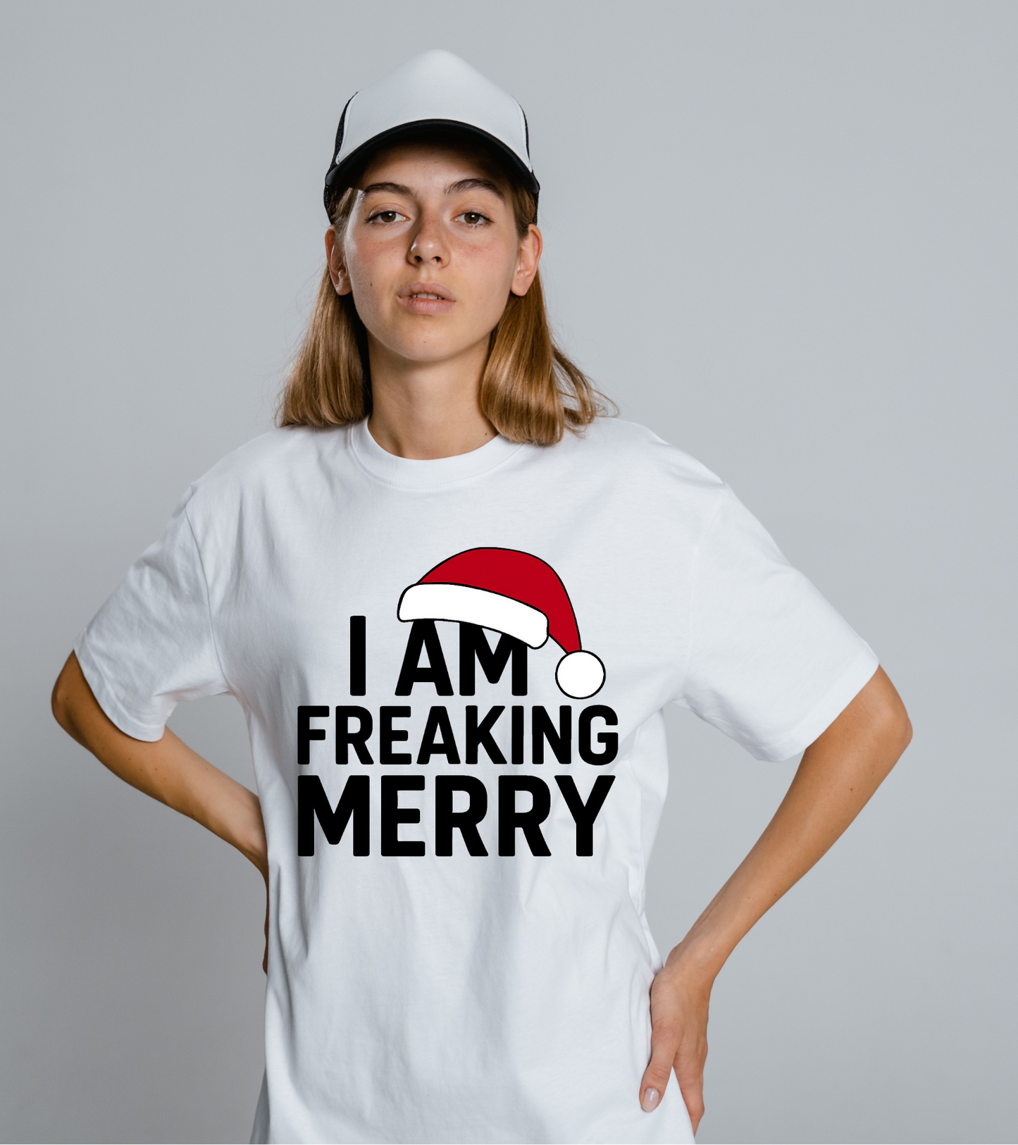 Person wearing a white t-shirt with 'I AM FREAKING MERRY' text and Santa hat graphic on a plain background