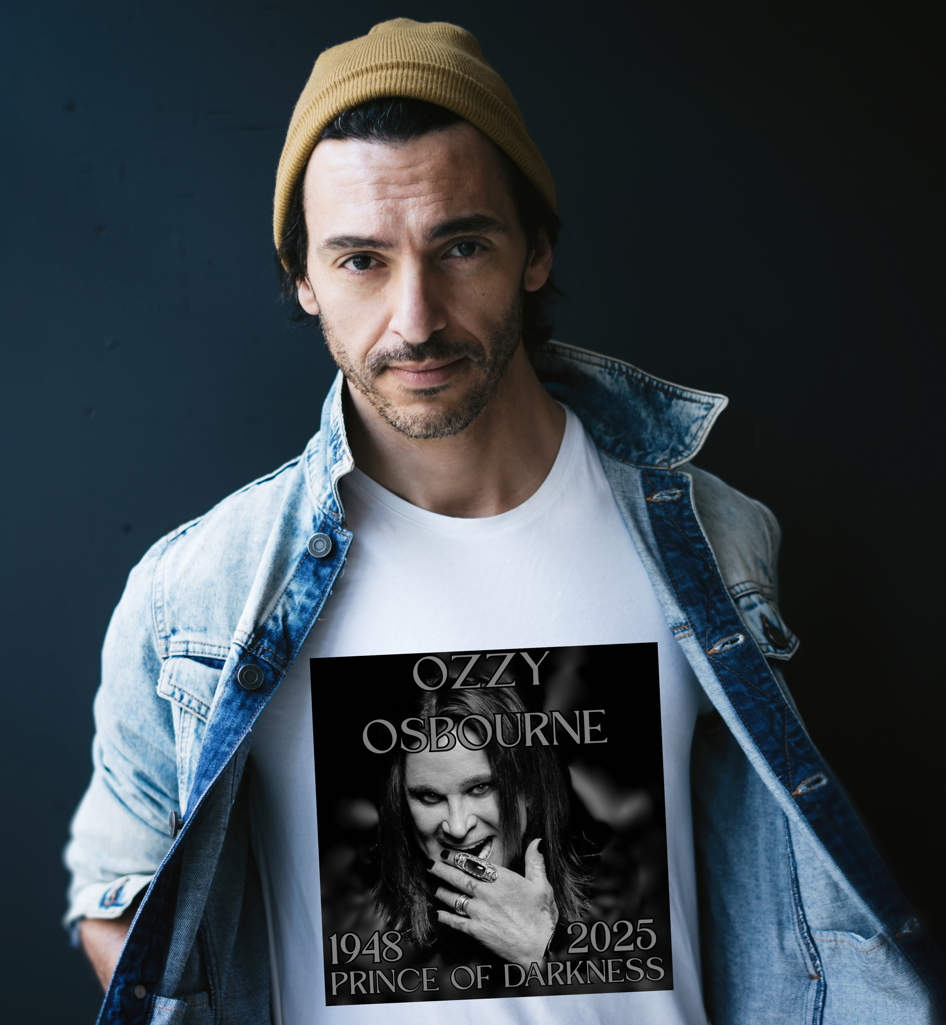 Man with white shirt and a jean jacket over the shirt and a beanie. The shirt is a photo of ozzy osbourne and shows the years 1948 - 2025. 