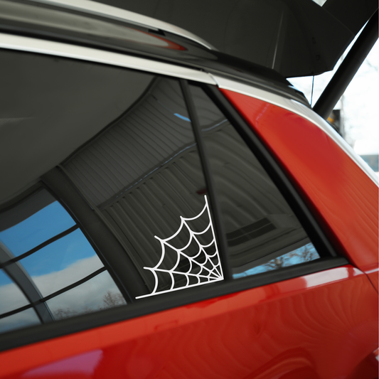 White vinyl spider web on a tinted window on a red suv