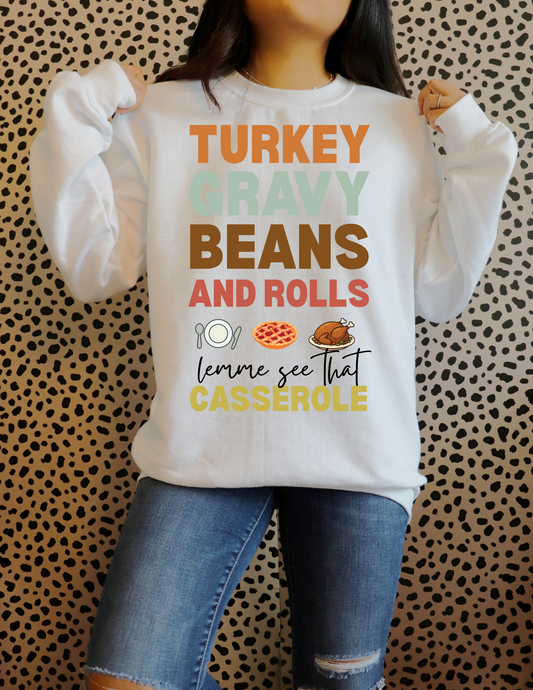 Person wearing a white sweatshirt with colorful text and graphics against a patterned background