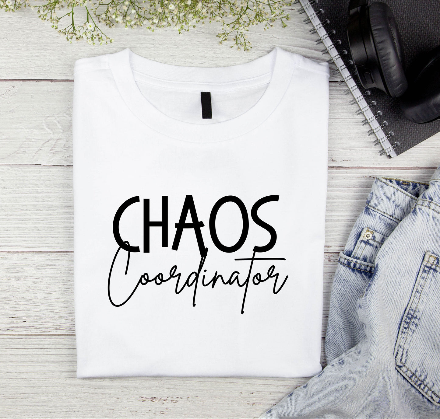 Folded white shirt with the words Chaos Coordinator on the front 