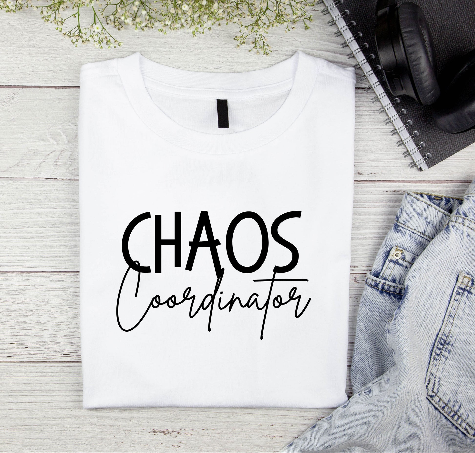 Folded white shirt with the words Chaos Coordinator on the front 