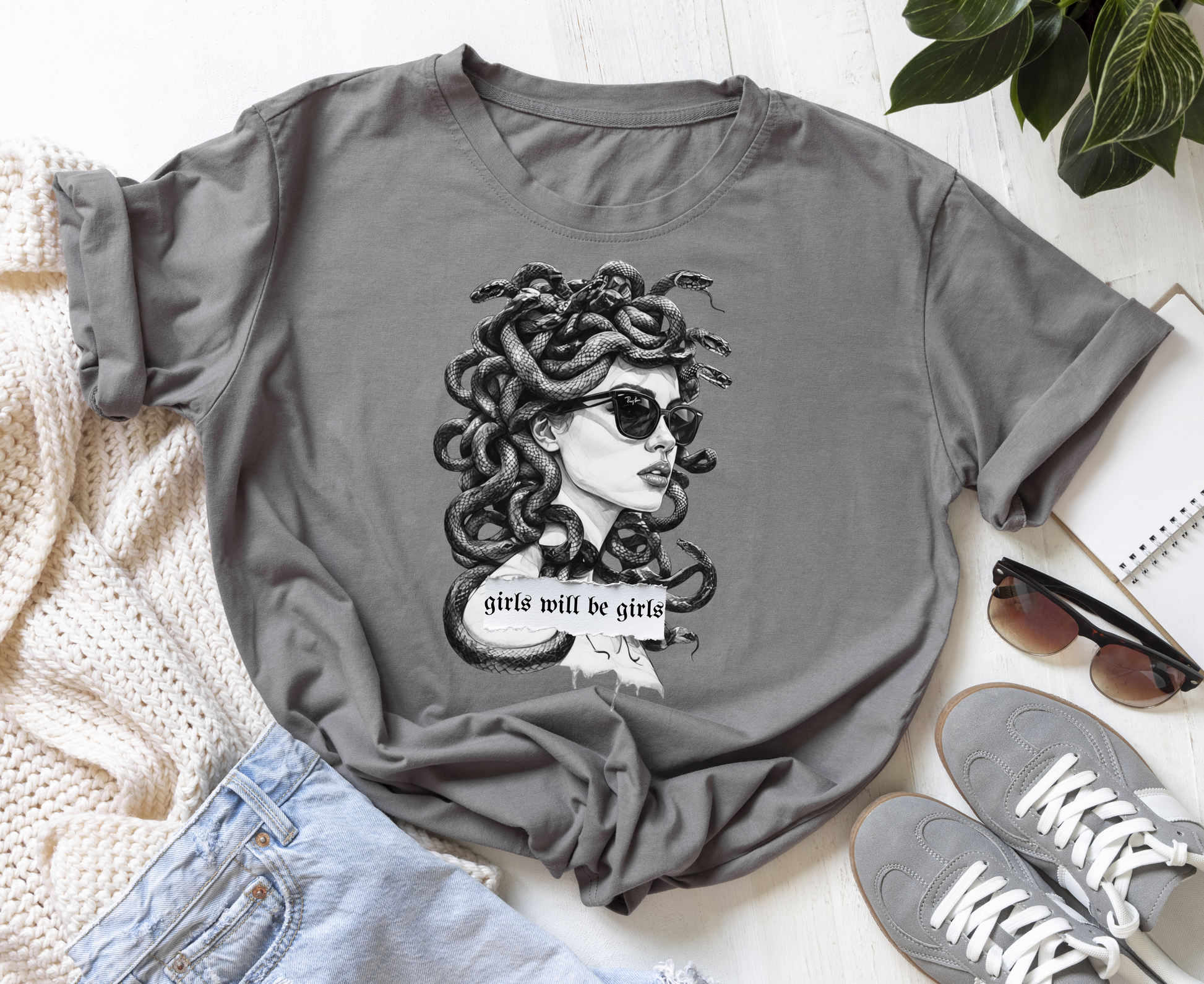 grey tee with sneakers. The shirt has an image of medusa with her hair of snakes wearing ray bans and the words girls will be girls across the front. 