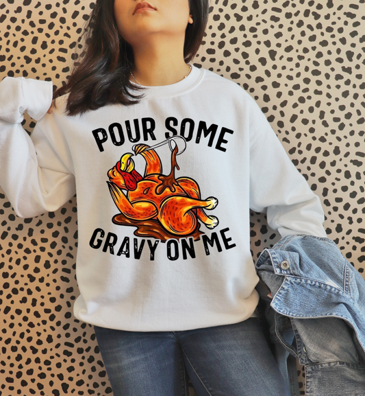 Person wearing a white sweatshirt with a graphic design and text against a patterned wall.