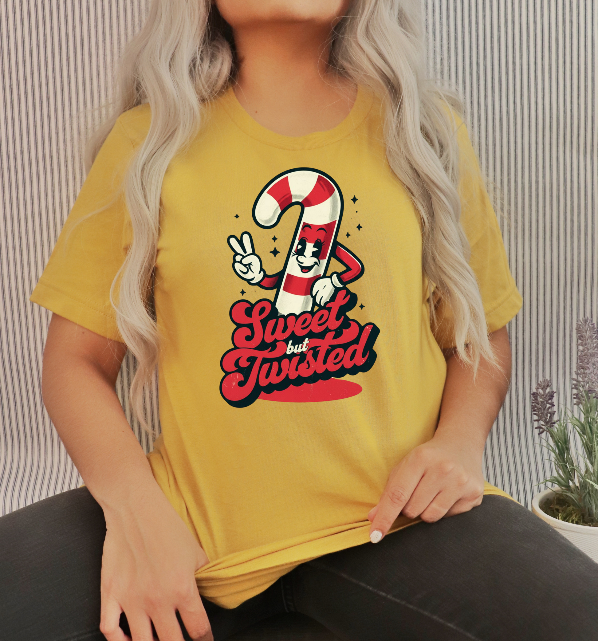 Person wearing a yellow t-shirt with a candy cane graphic design and text.
