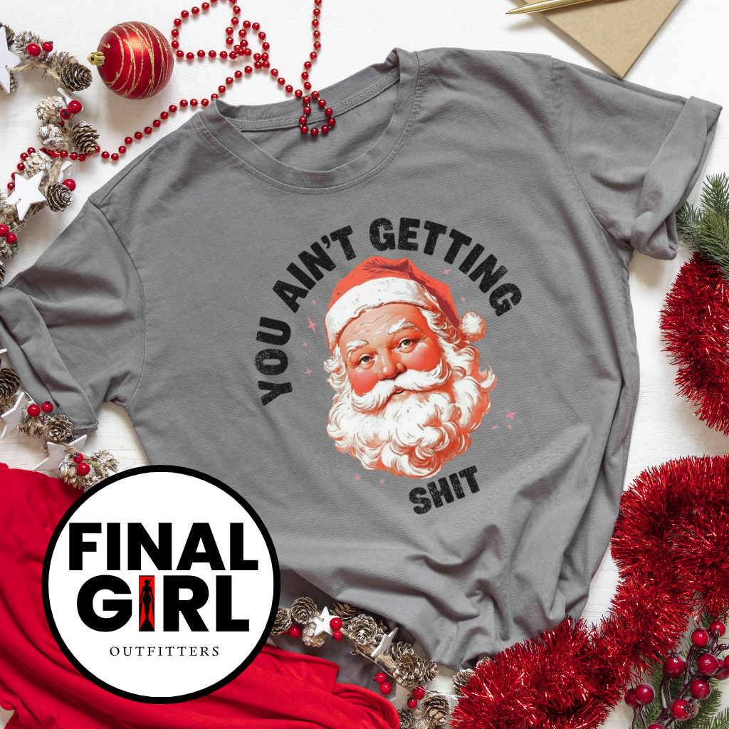 Gray t-shirt with Santa Claus graphic and text, surrounded by Christmas decorations, featuring 'Final Girl Outfitters' logo.